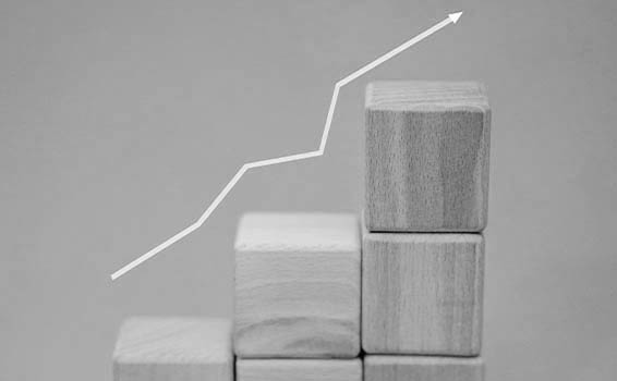 Növekedést mutató grafikon fakockákon, ami a weboldal és a hirdetések összehangolását, valamint az olcsóbb kattintási költségeket eredményező ökoszisztémát mutatja.