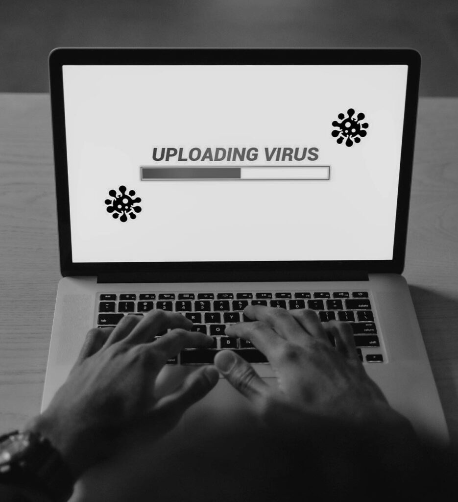 Vírusfeltöltést mutató laptop képernyő, amely a karbantartás hiányának veszélyeire és a weboldalak páncélterem szintű vírusvédelmére, valamint tűzfalára hívja fel a figyelmet.